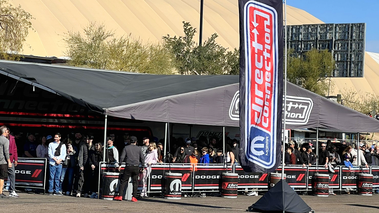 Enthusiast attendees mingle in line at the Dodge space within Barrett-Jackson