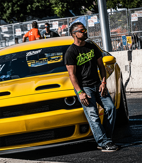 Man leaning on a custom yellow Dodge Challenger SRT Hellcat