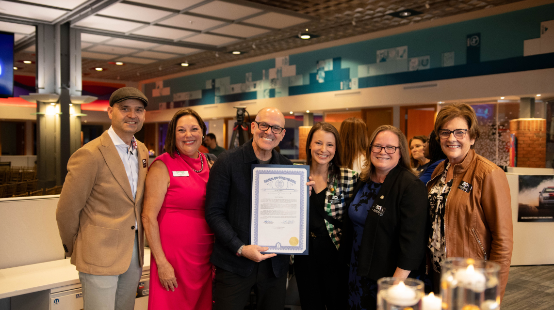 Mark Bellissimo holds a certificate with the Mayor of Farmington Hills, Therese Rich, and others at the JRT agency's 50 Forward event