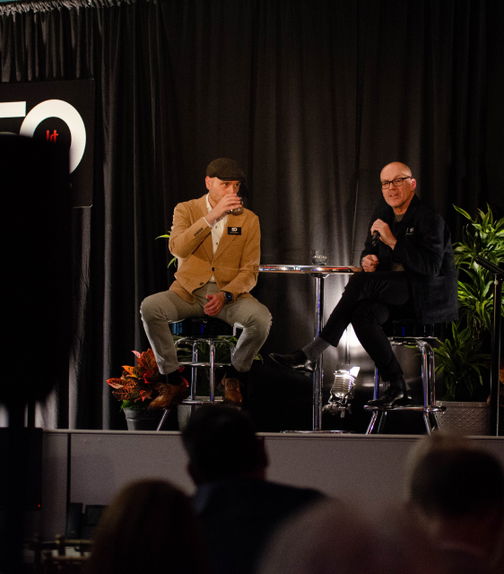 Mark Bellissimo of the JRT agency and Nikola Danaylov in an event photo of lighted stage and 50th logo