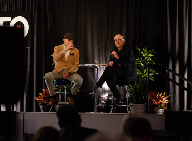 Mark Bellissimo of the JRT agency and Nikola Danaylov in an event photo of lighted stage and 50th logo