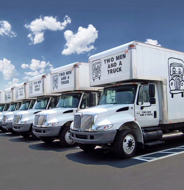 An image of trucks wrapped with the two men and a truck logo